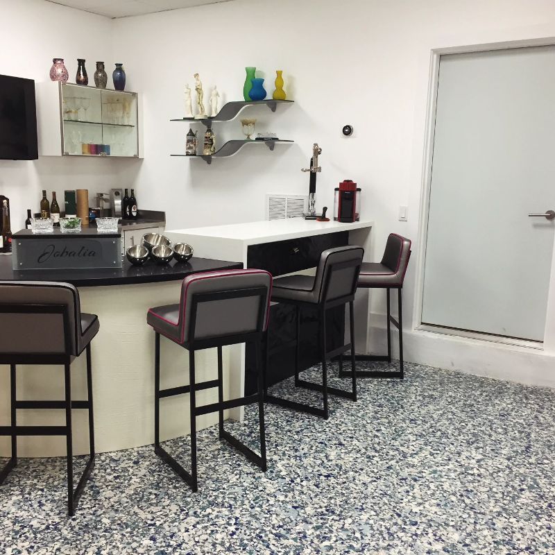 A room with a bar and chairs and a sign that says cadillac