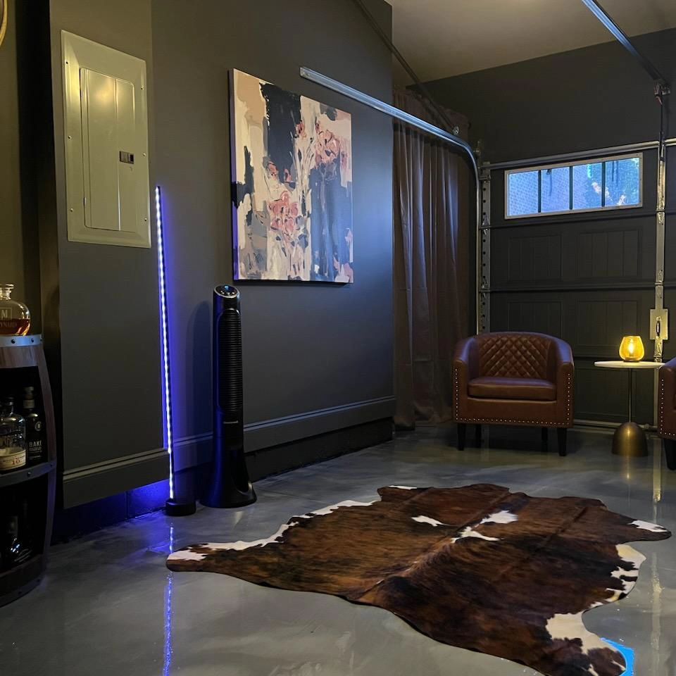 A living room with a cowhide rug and a painting on the wall