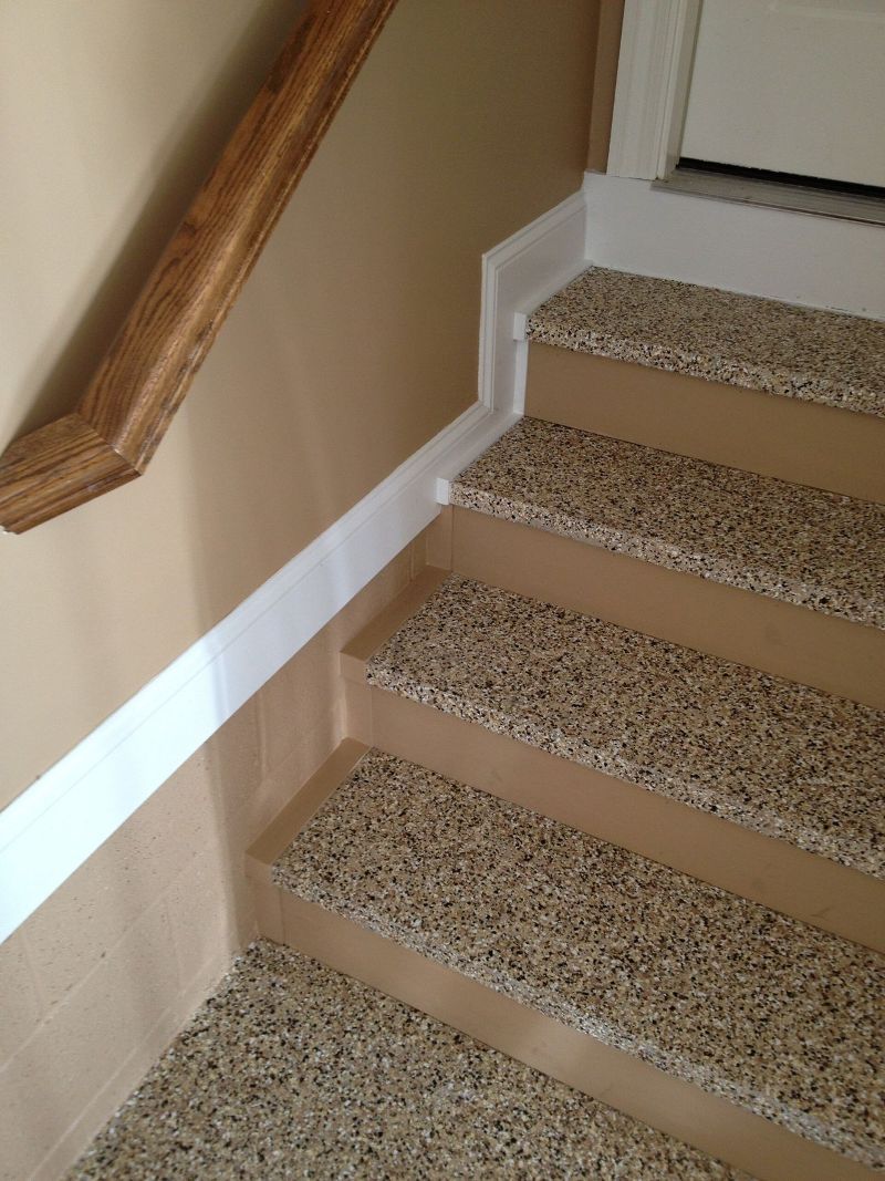 A set of stairs with carpeted steps and a wooden railing.