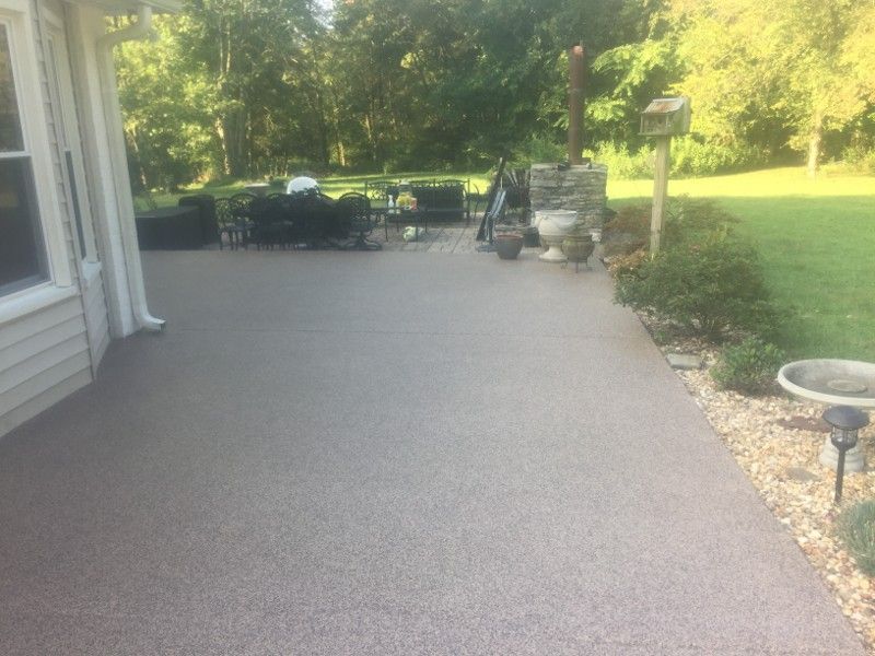 A patio with a bird bath in the backyard of a house.