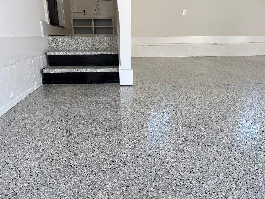A garage with a concrete floor and stairs leading up to it.
