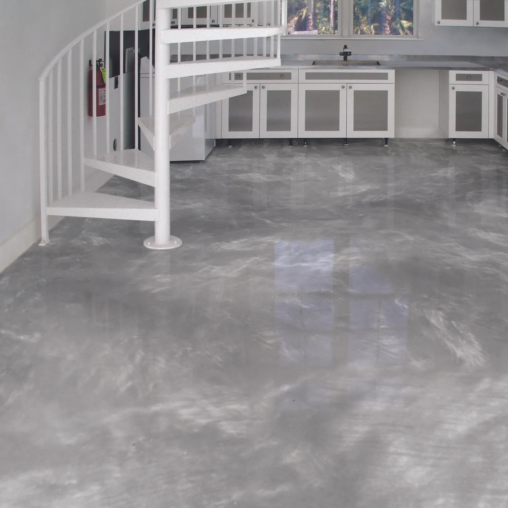A kitchen with a spiral staircase and a gray floor.