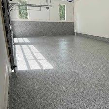 A garage with a basketball hoop and a gray floor.