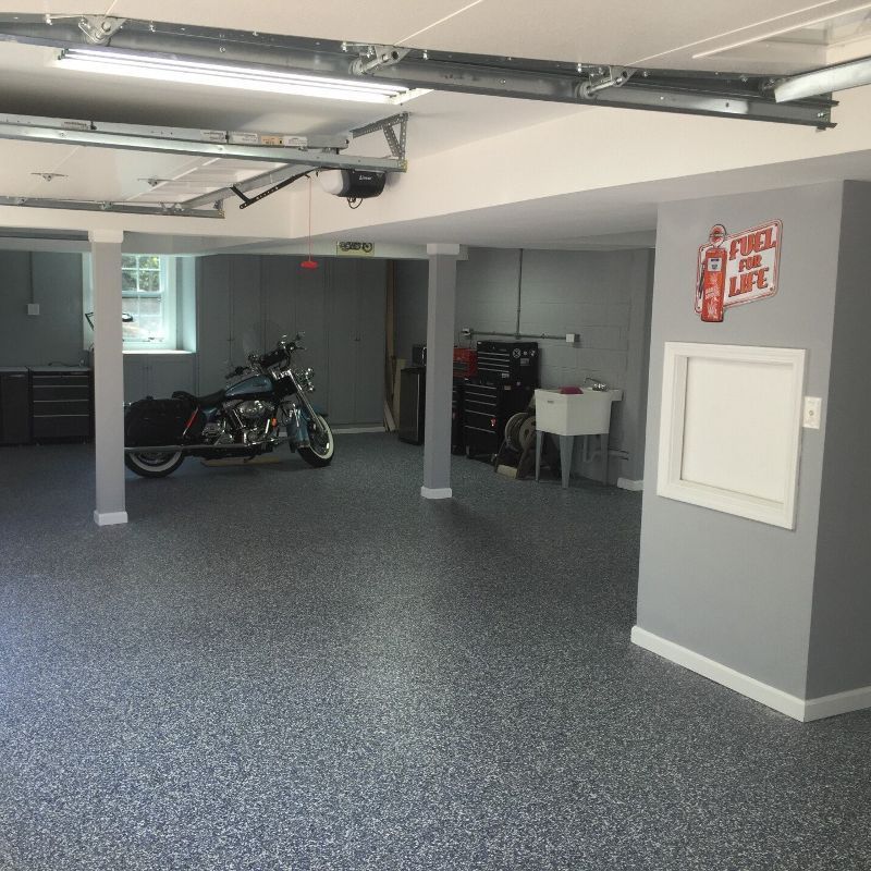 A motorcycle is parked in a garage next to a sink