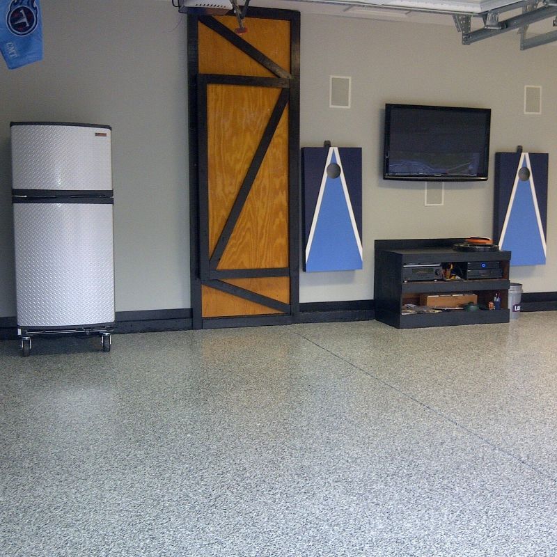 A room with a refrigerator and a flat screen tv