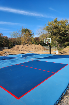 A blue and red basketball court with a basketball hoop.