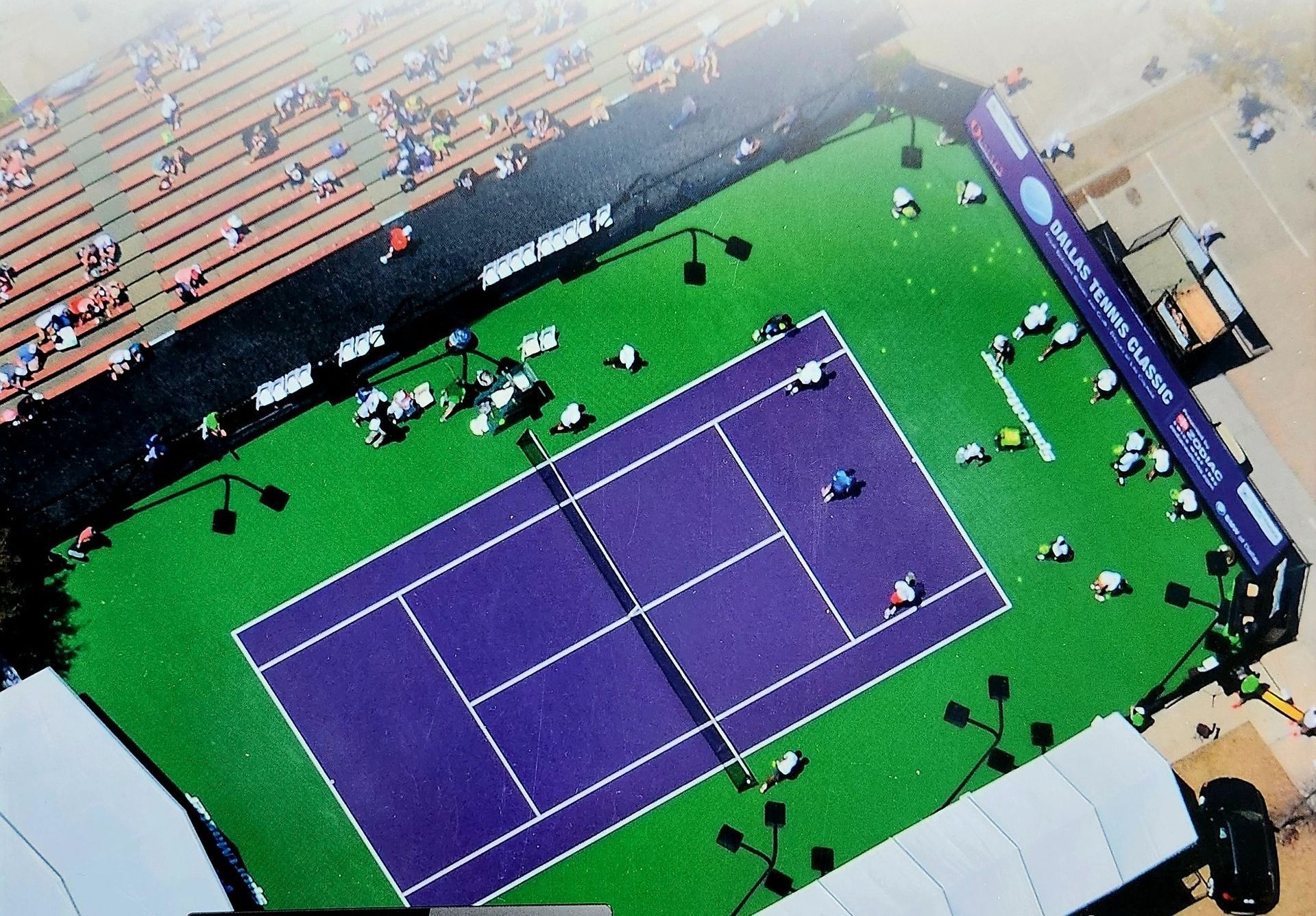 An aerial view of a tennis court sponsored by premium sport surfacing products