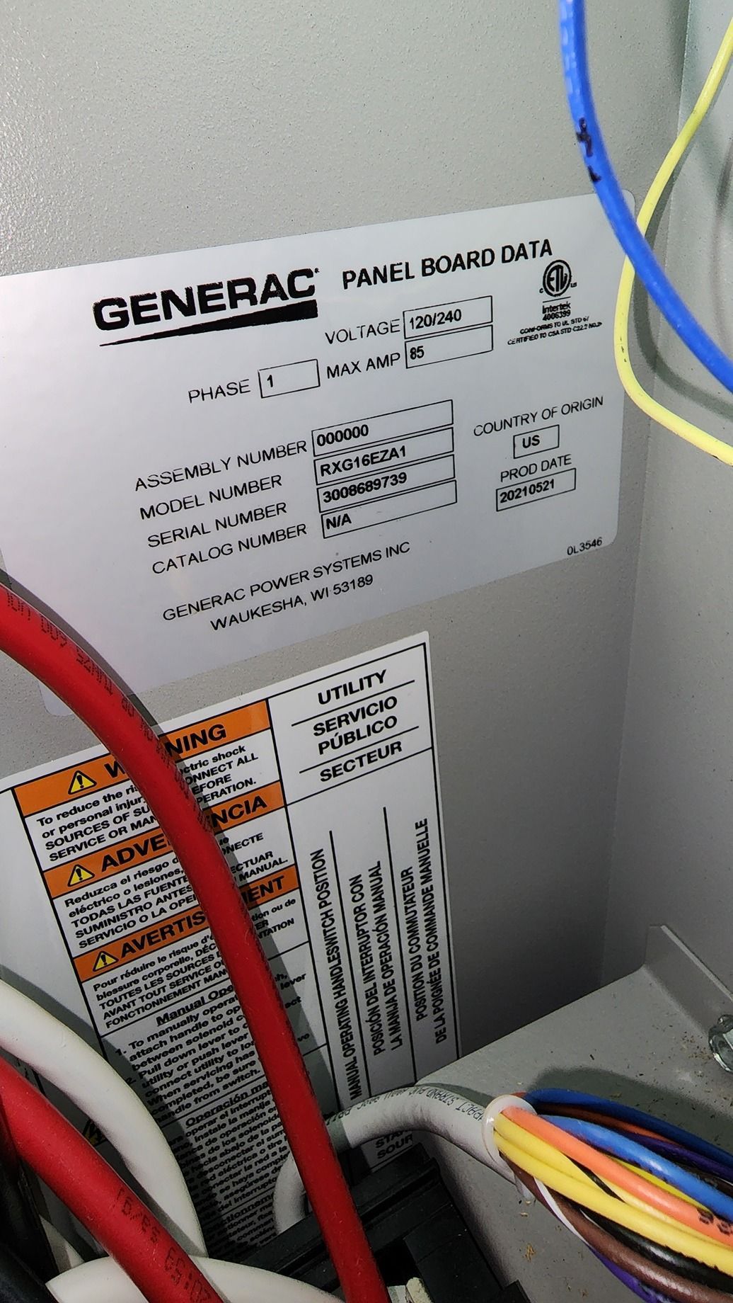 Close-up of a Generac electrical panel with colored wires inside a gray cabinet.