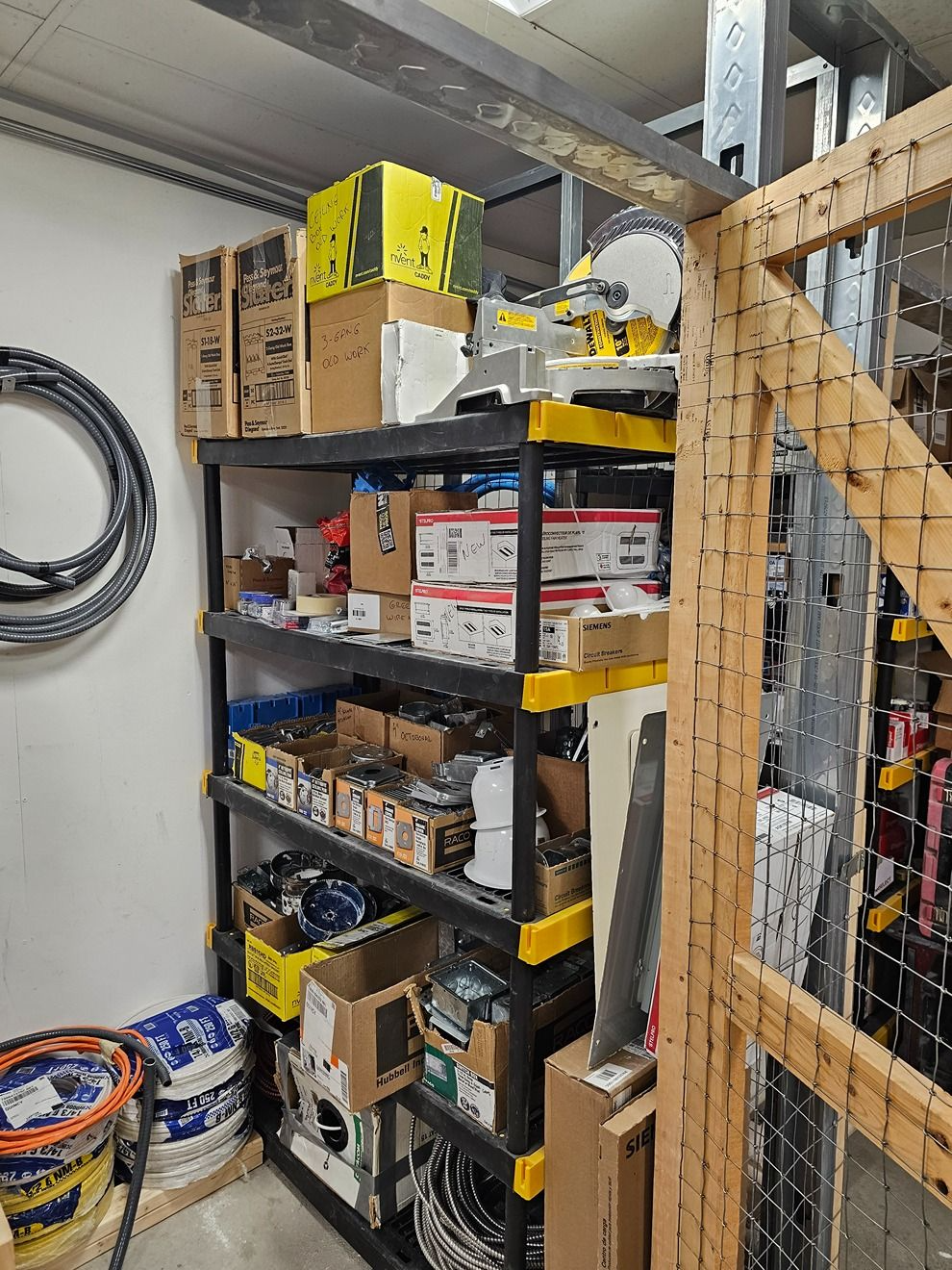 Shelved storage area with boxes, tools, and supplies in a garage or workshop