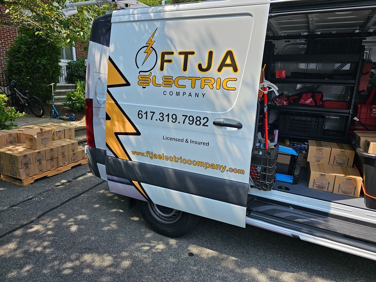 FTJA Electric van with open side door, showing tools and equipment at a job site.