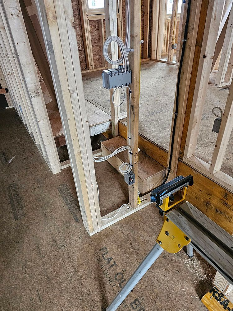 Framing crew laser level measuring a wall opening in a construction site.