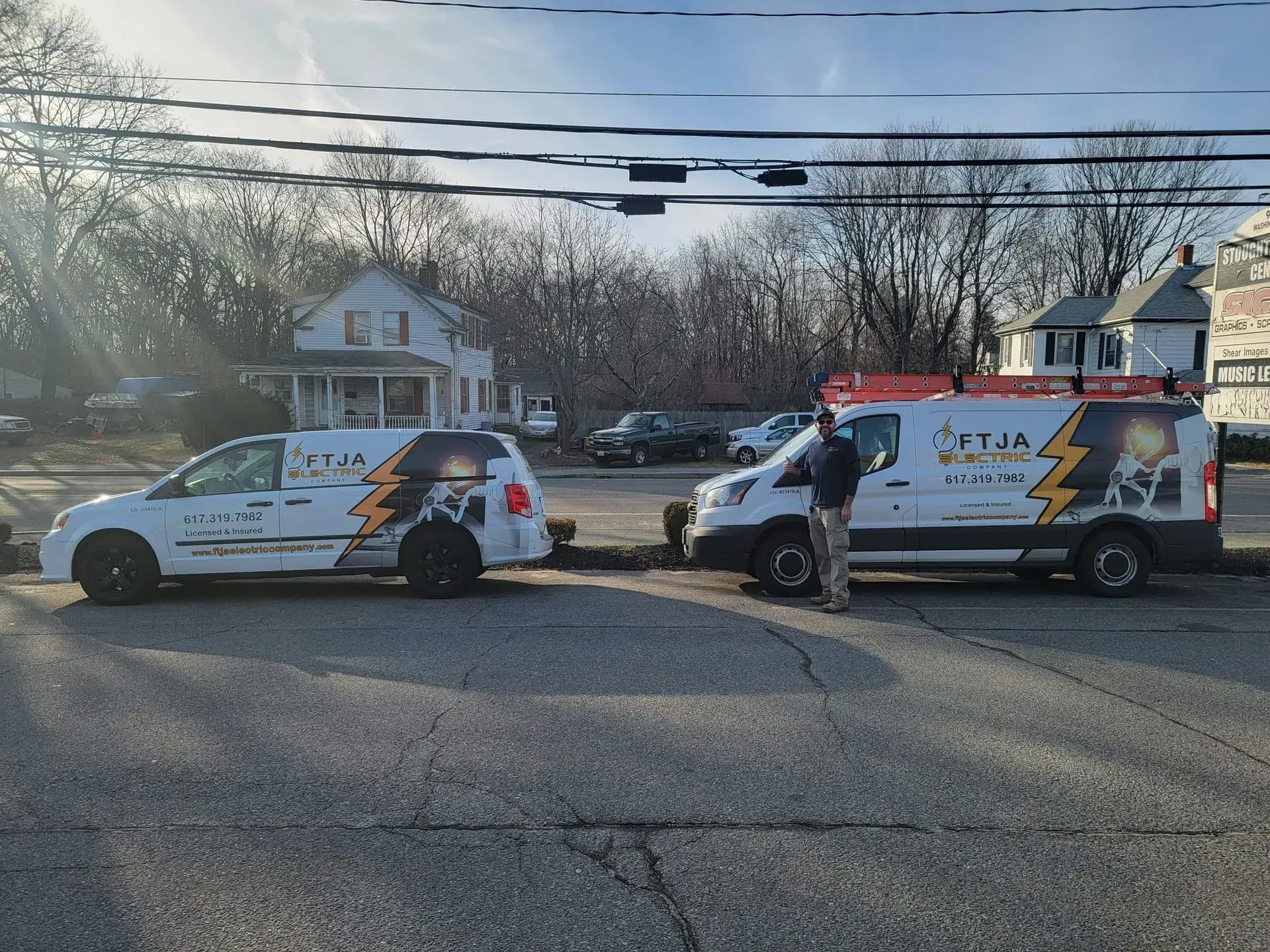 Two police SUVs parked across a road with an officer standing beside the right vehicle.