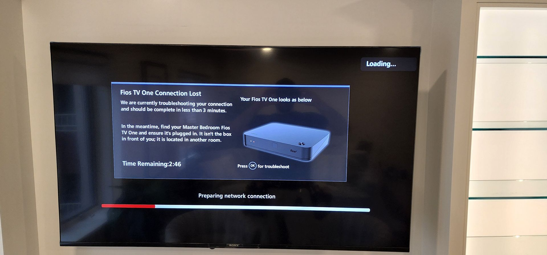 TV screen showing a software installation/update menu with progress bar on a wall-mounted display