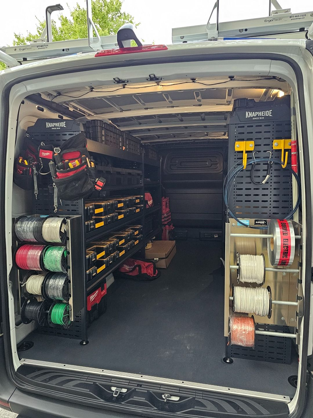 Open van with organized tool storage, hoses, reels, and equipment racks inside the cargo area