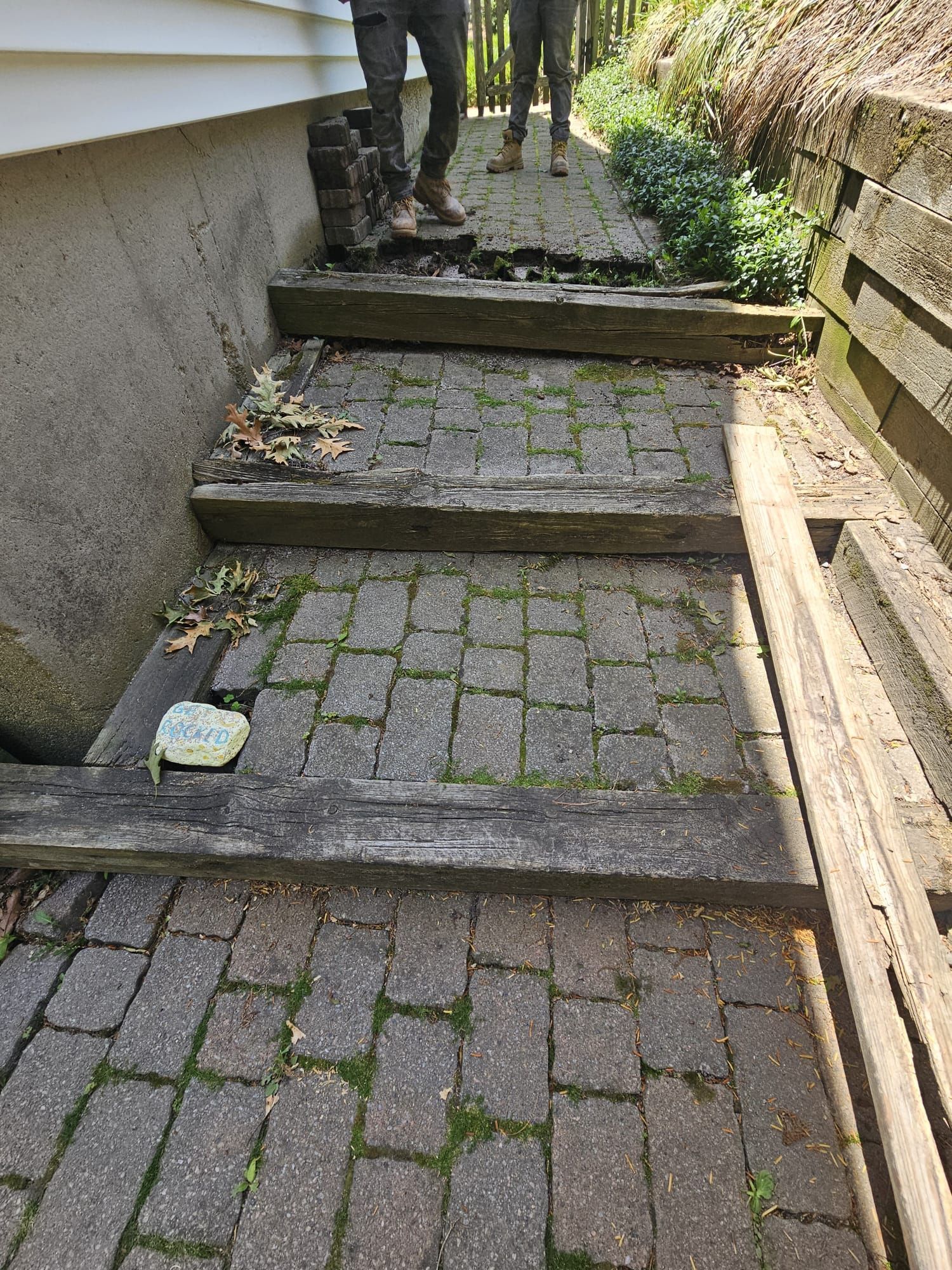 Narrow outdoor stone steps with uneven paving and two people standing at the top.