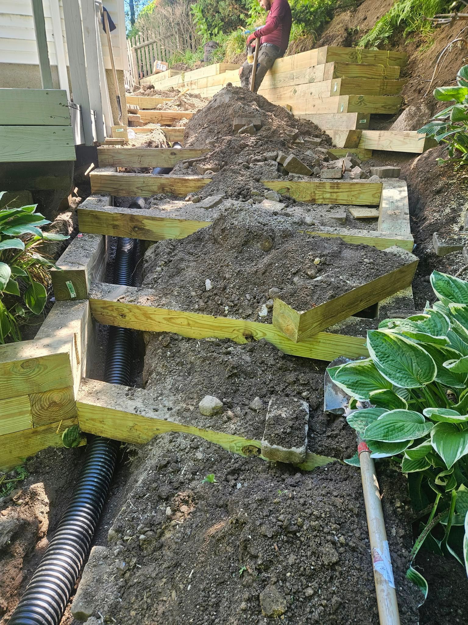 Steep concrete steps with broken, uneven surfaces and a person working at the top of the stairway.