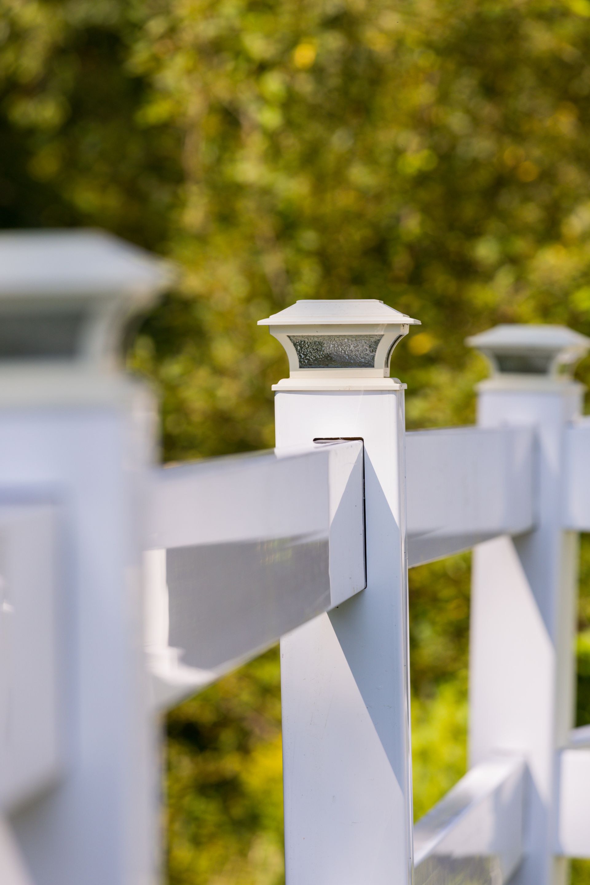 A close up of a white fence with a light on top of it.