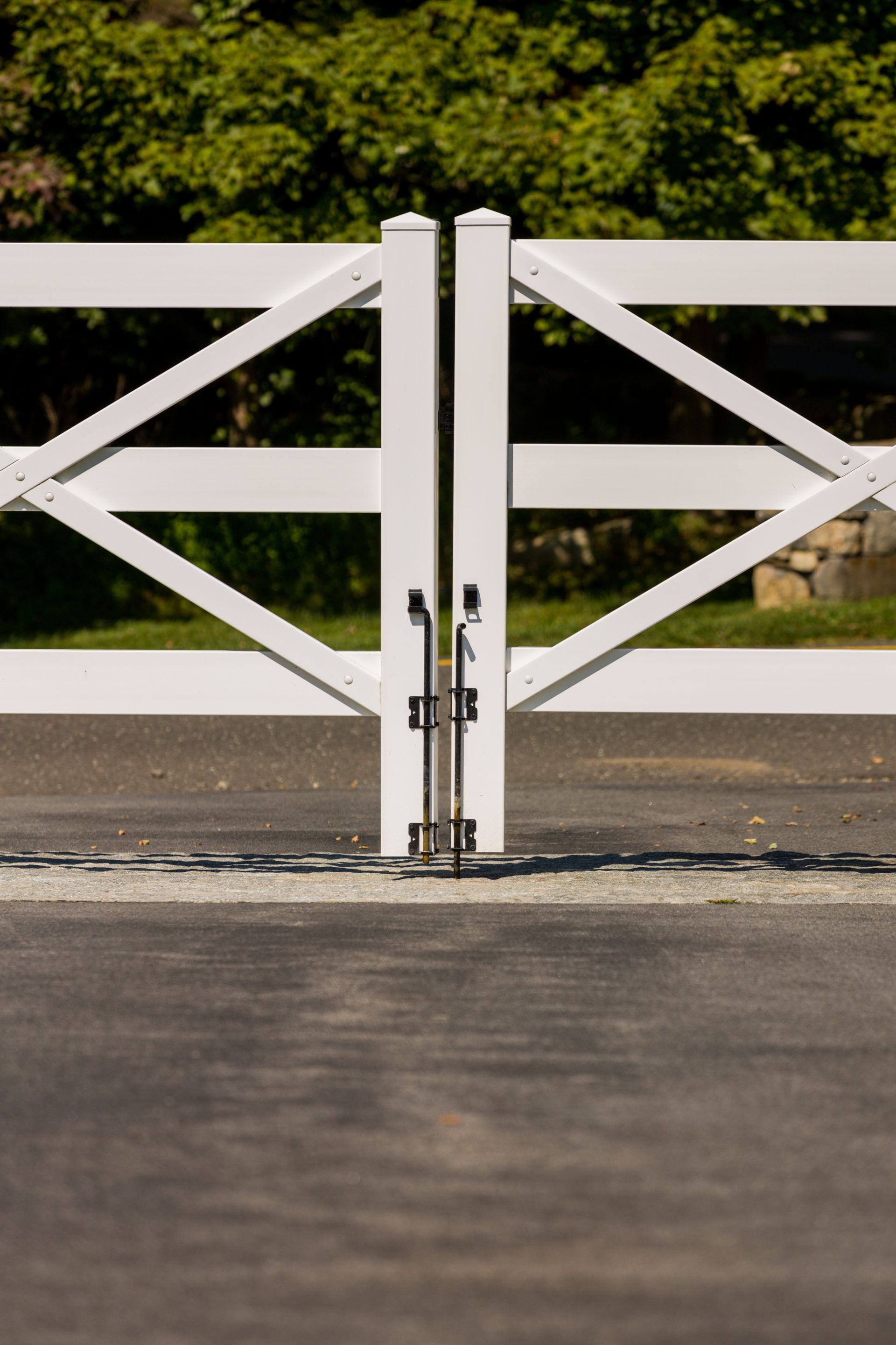 A white fence is sitting on the side of a road.
