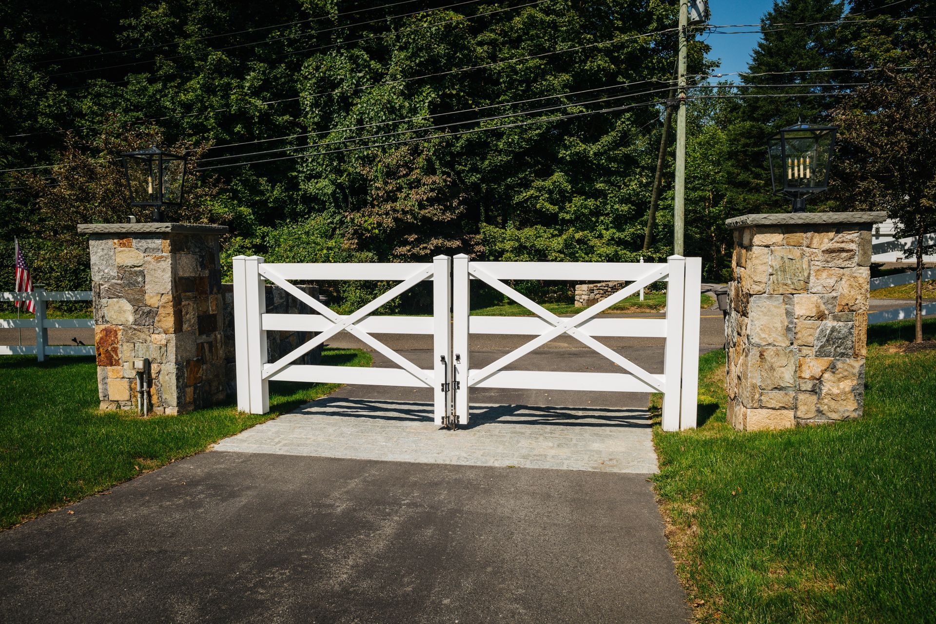 A white gate is sitting on the side of a road.