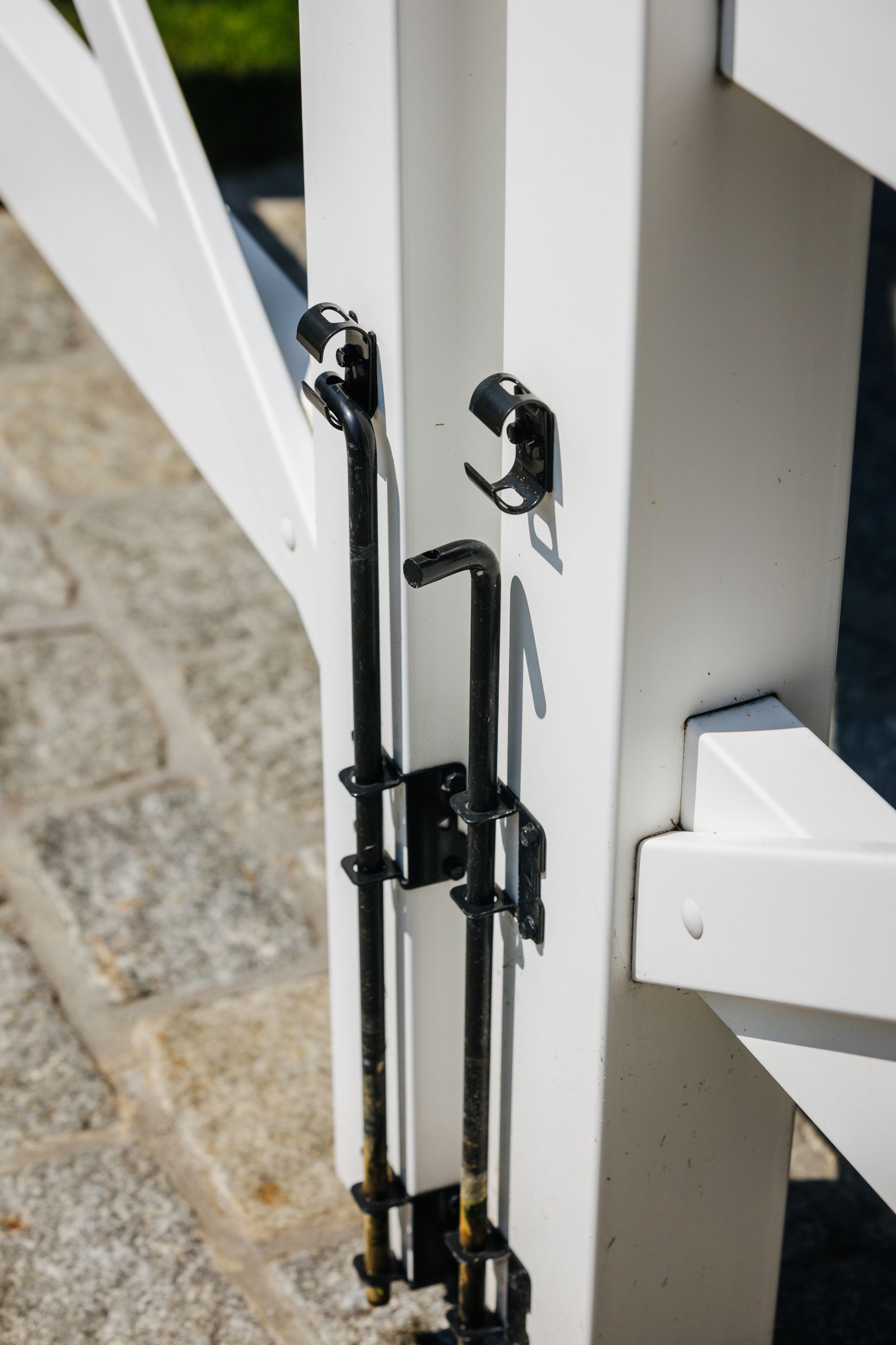 A close up of a white gate with a black latch.