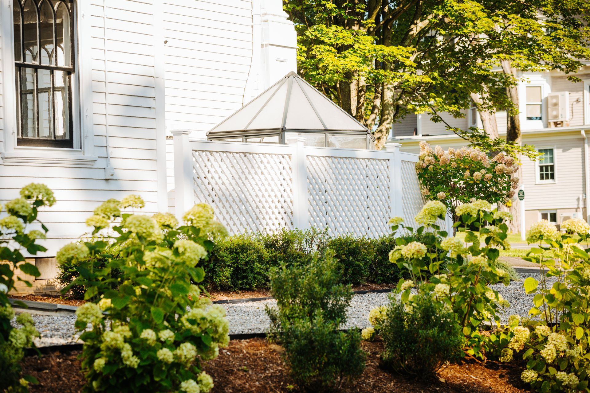 A white house with a gazebo in the backyard