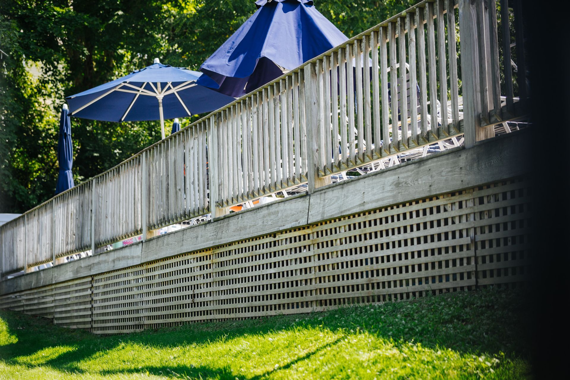 A wooden fence with a blue umbrella on it