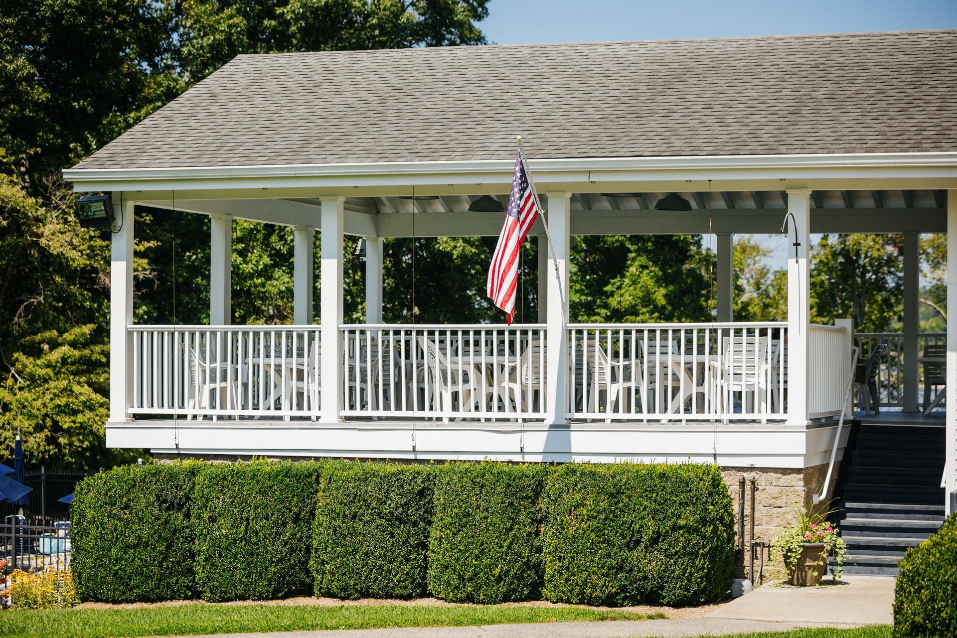 A white house with a porch and an american flag on it