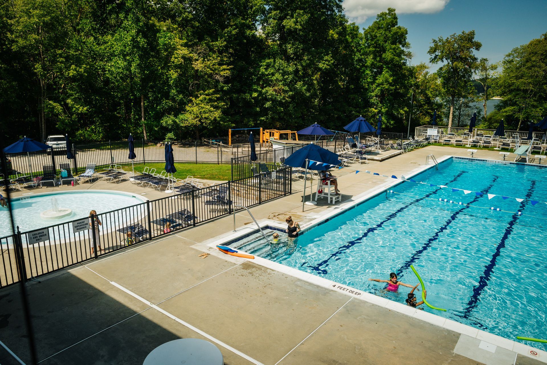 An aerial view of a swimming pool with people swimming in it