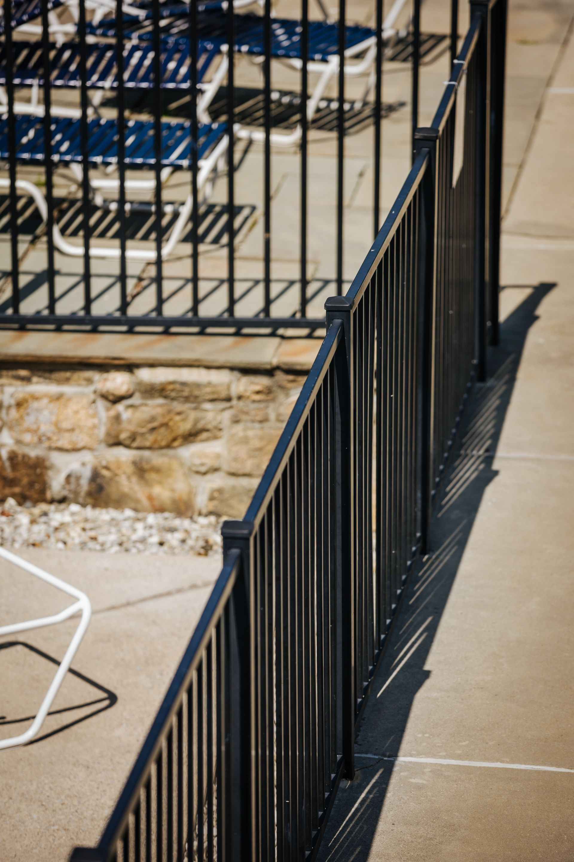 A black metal fence surrounds a swimming pool