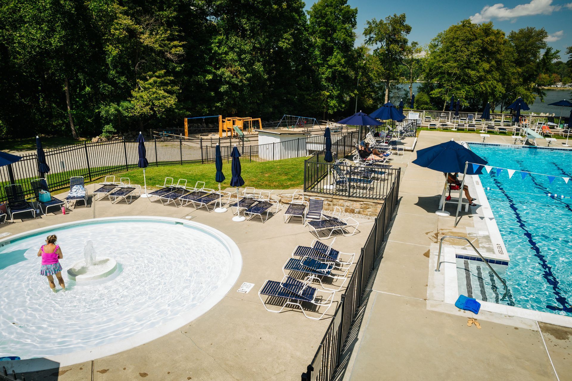 An aerial view of a large swimming pool surrounded by chairs and umbrellas.