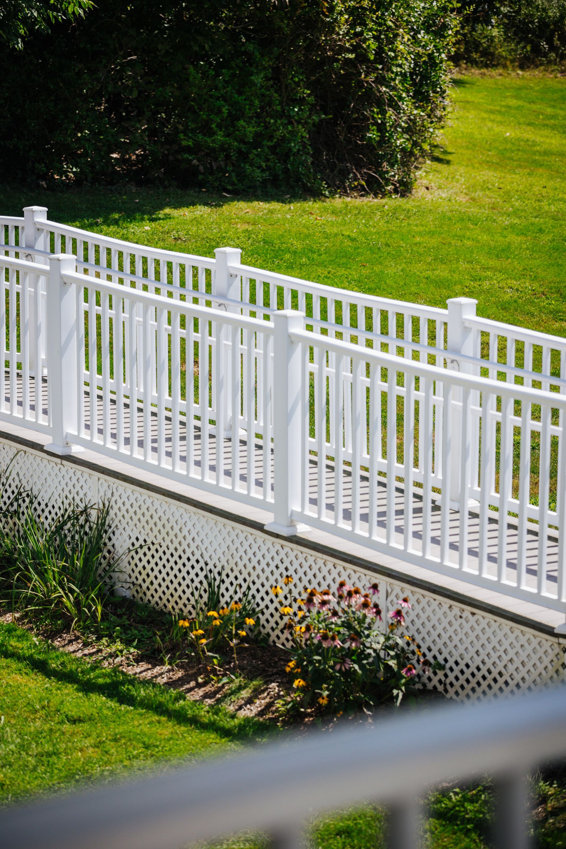 A white fence surrounds a lush green yard.