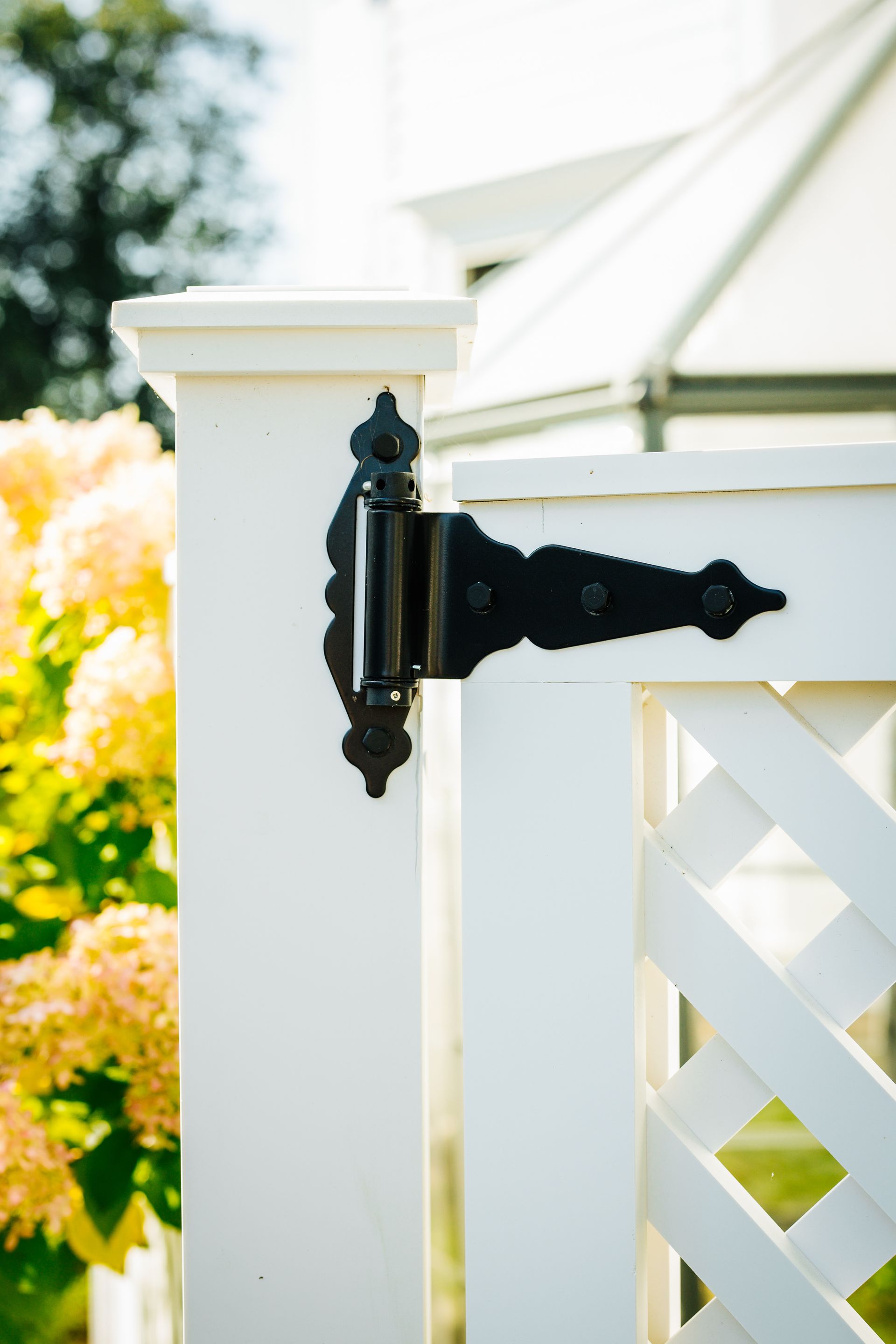 A white fence with a black hinge on it