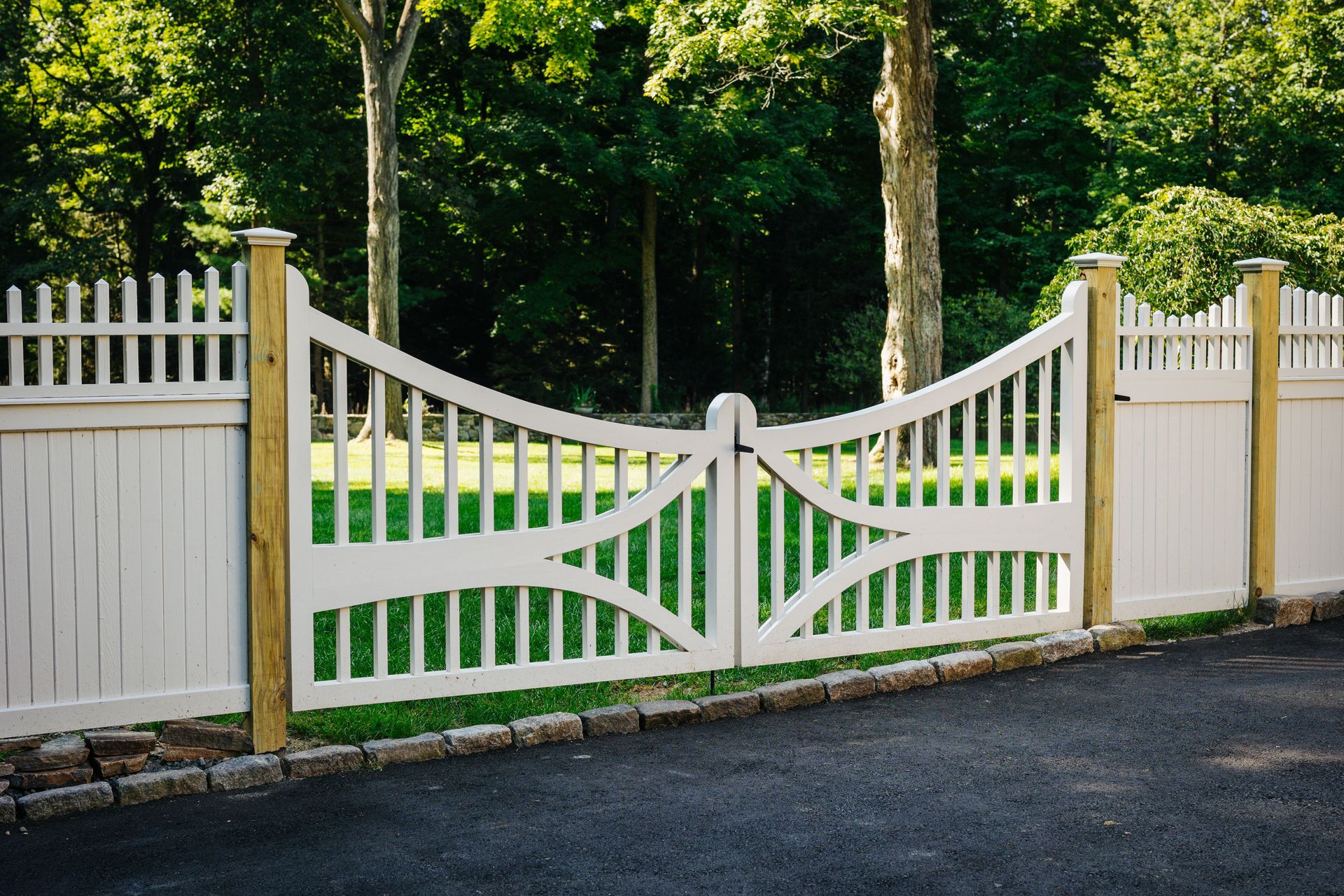 A white fence with a gate in the middle of it