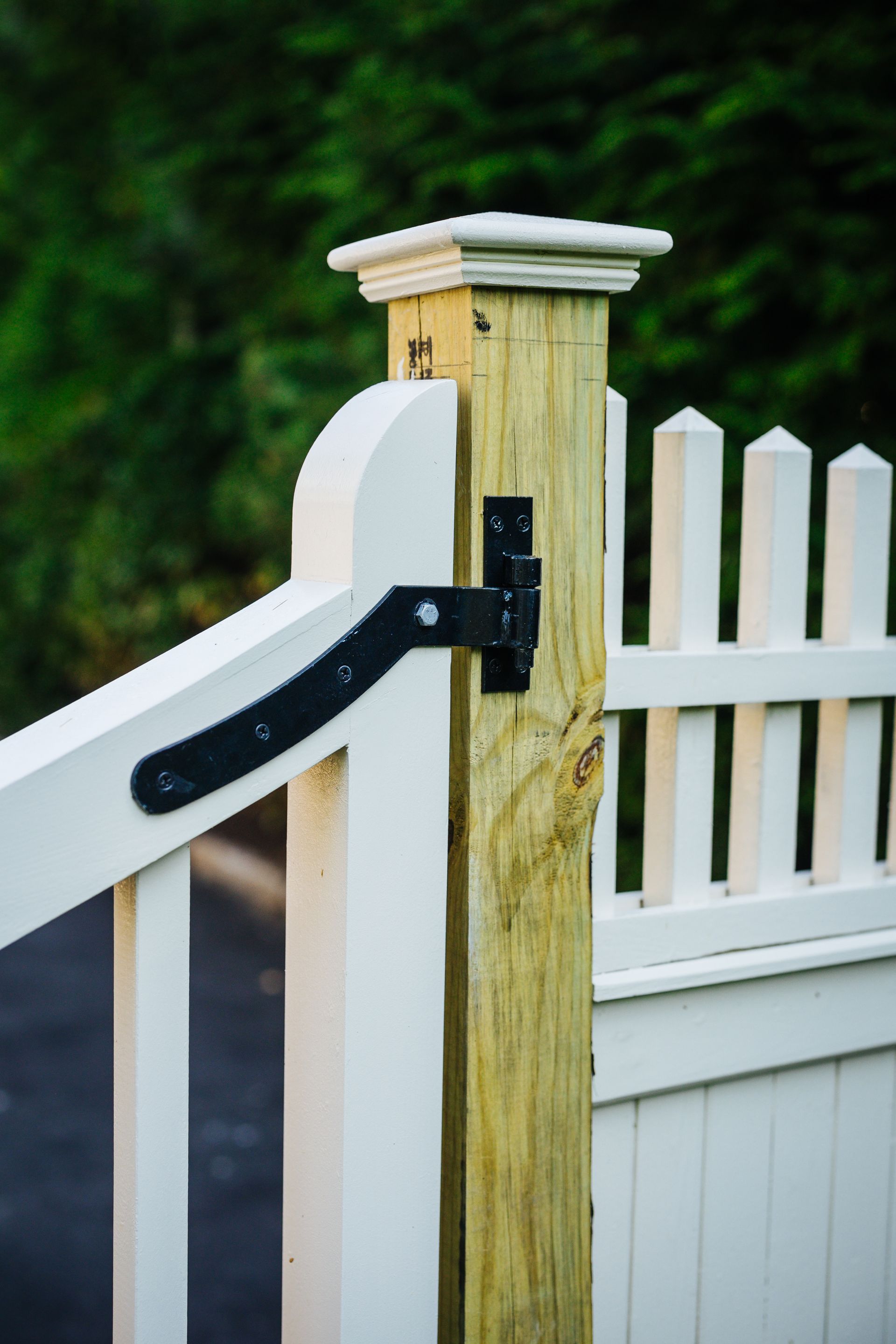 A white picket fence with a wooden post attached to it