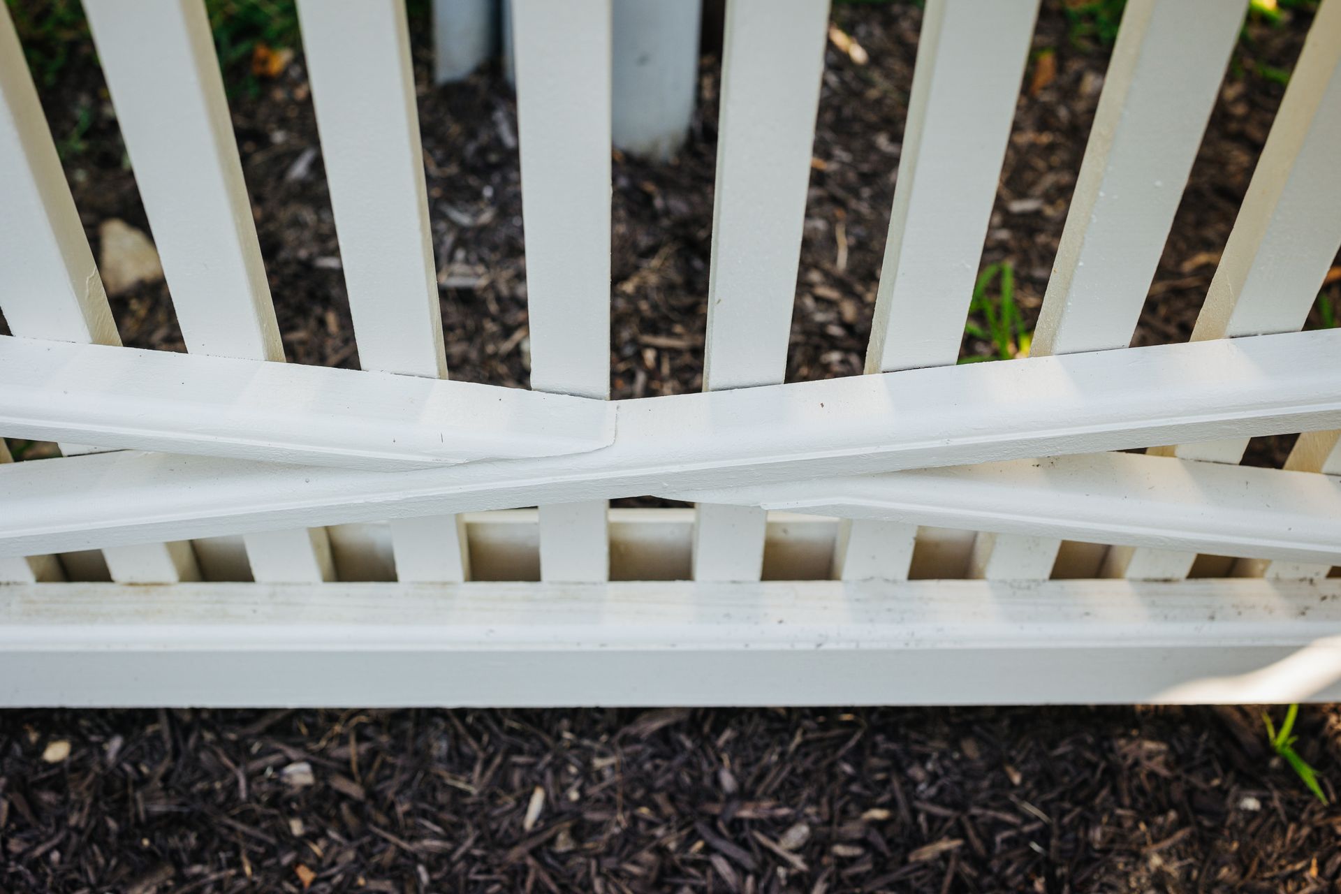 A close up of a white wooden fence with a broken railing.