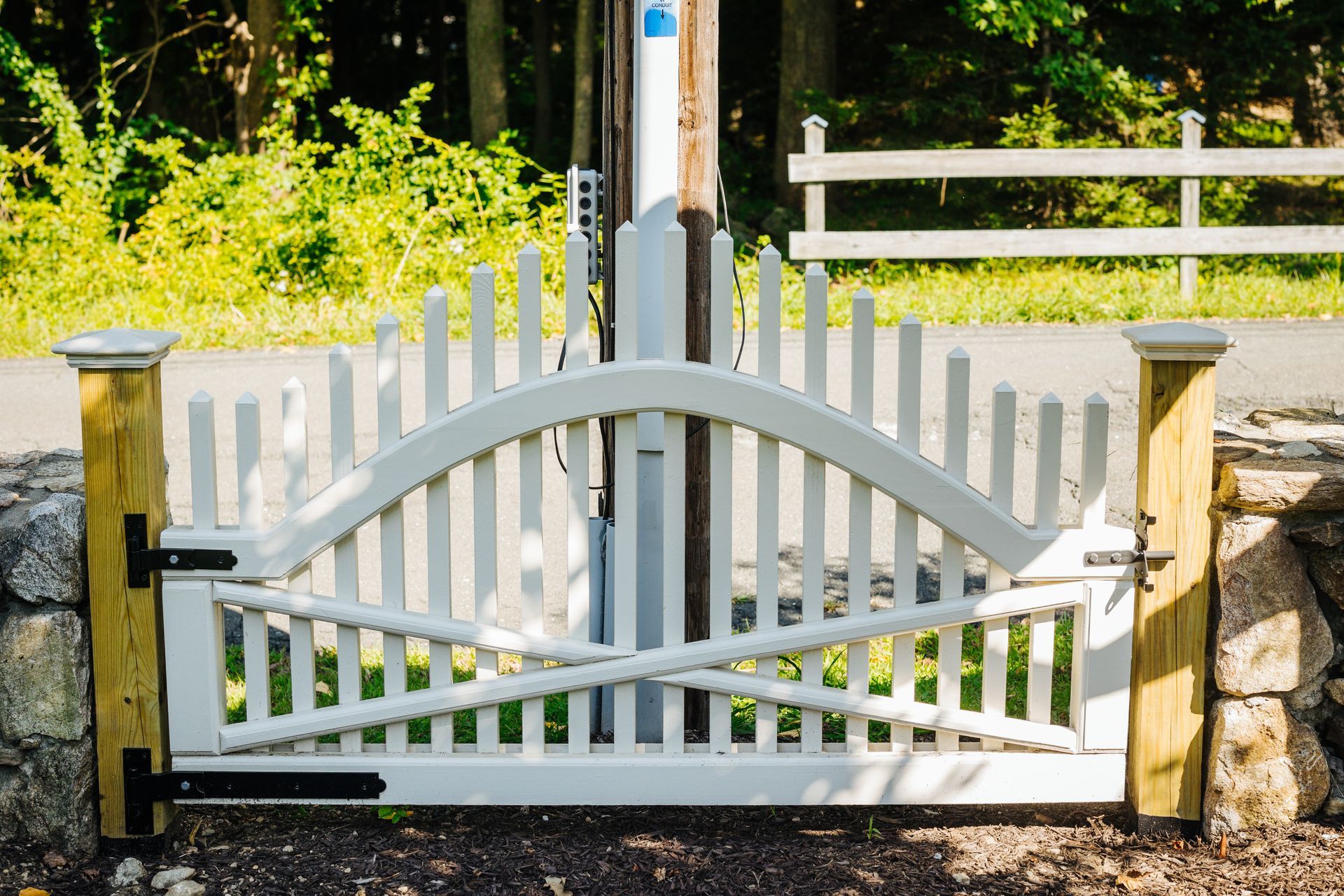 A white picket fence with a wooden post and gate