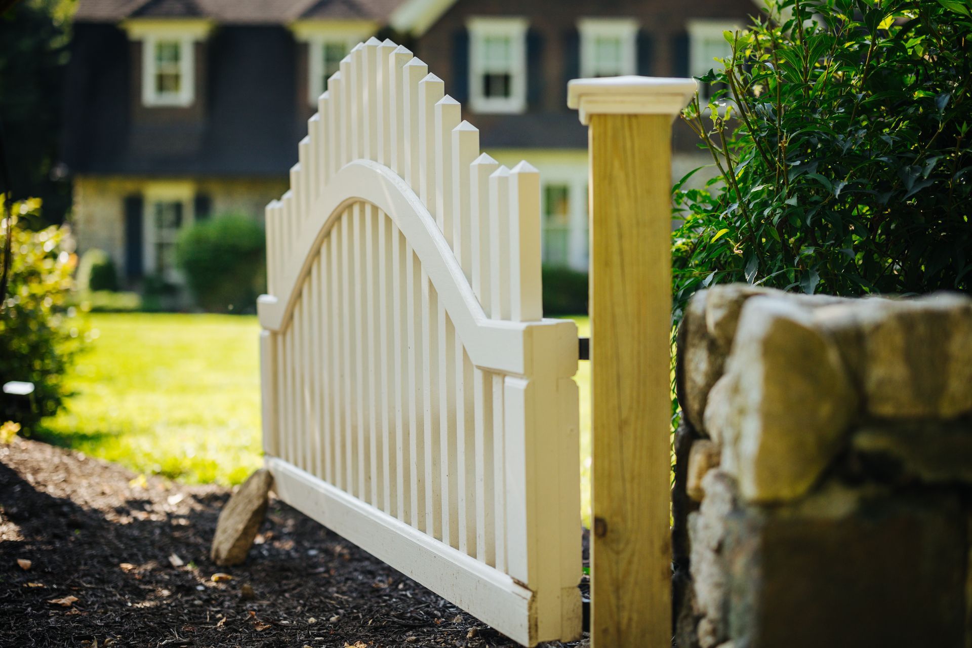 A white picket fence is sitting in front of a house.