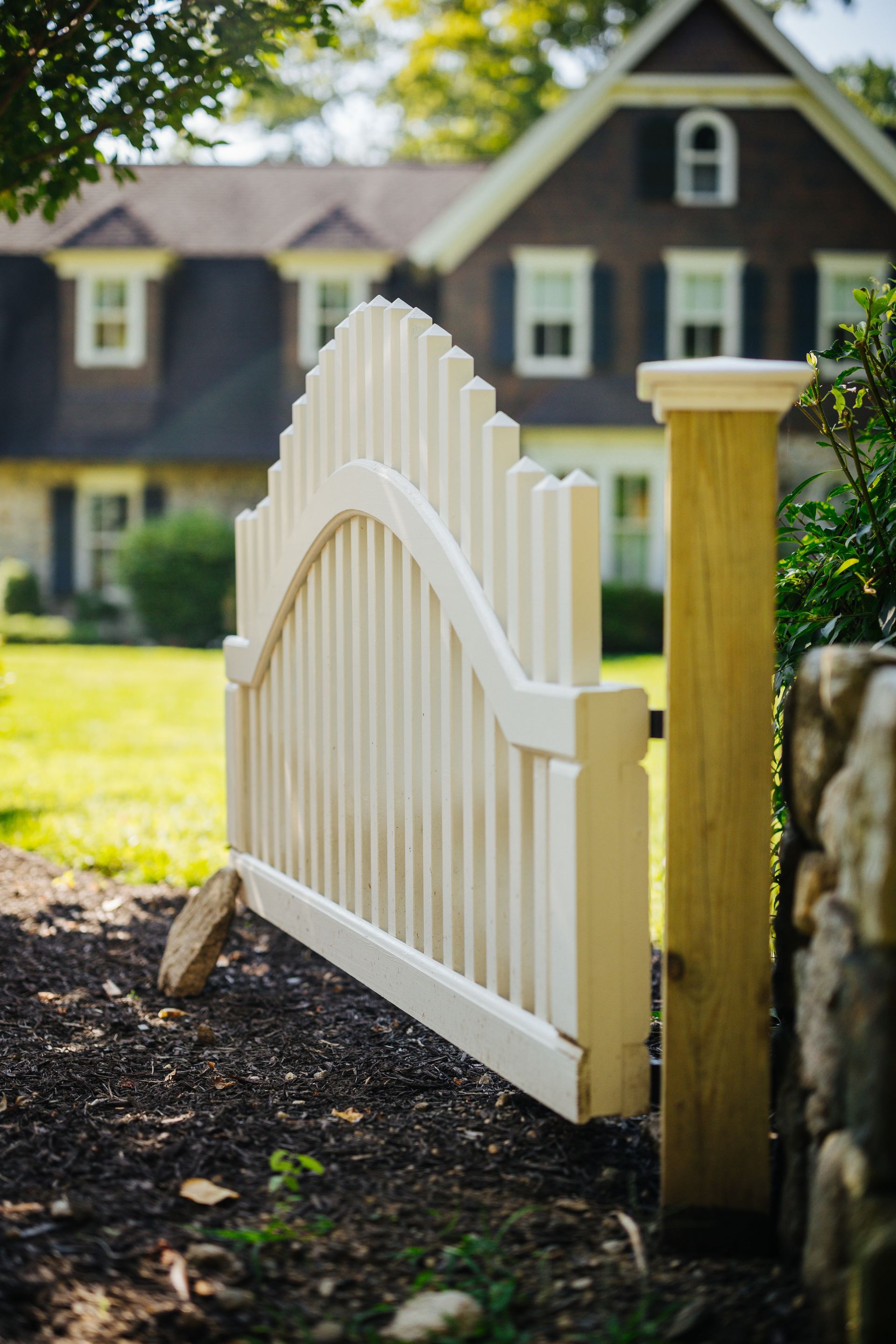 A white fence is sitting in front of a house.