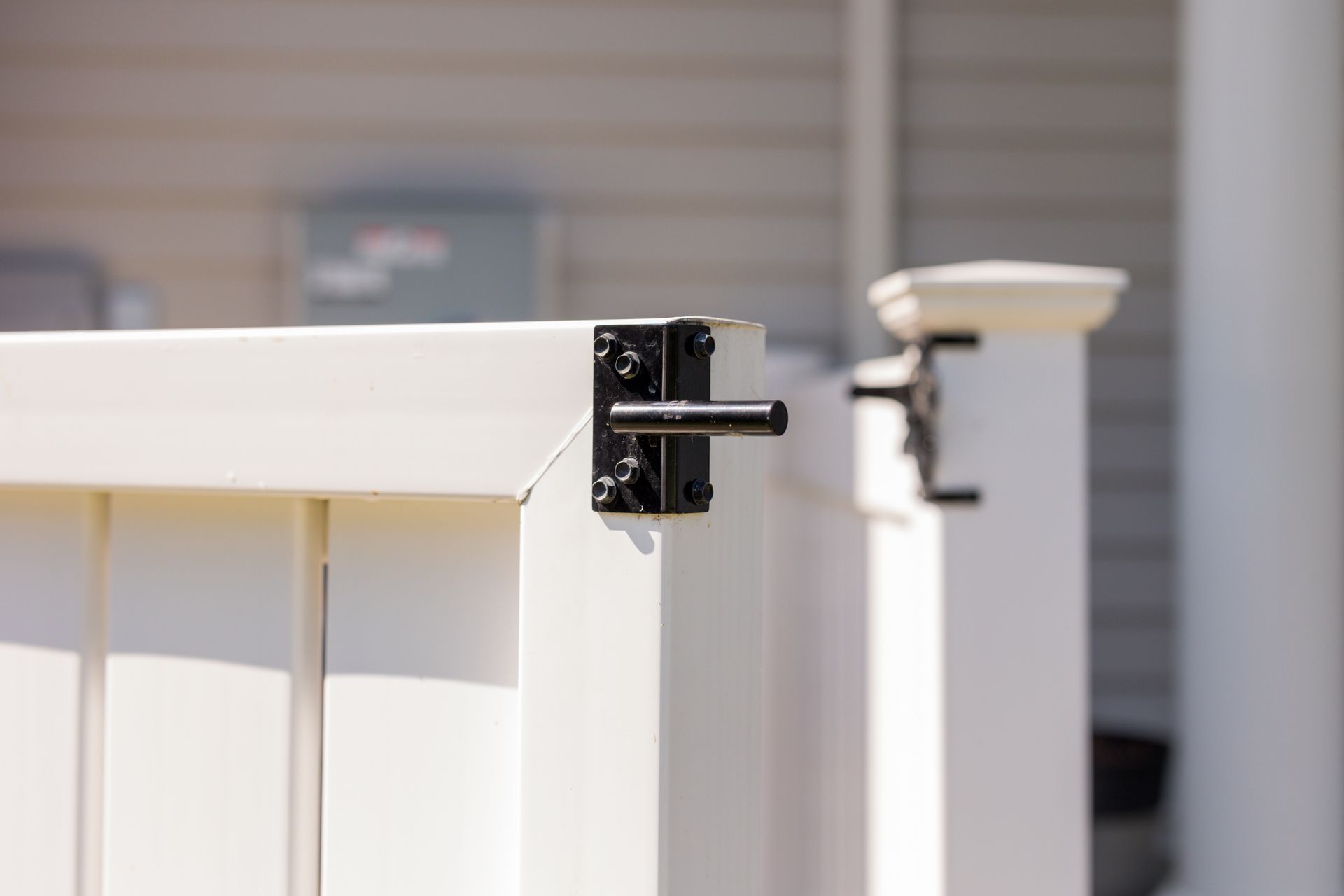A close up of a white fence with a black latch.