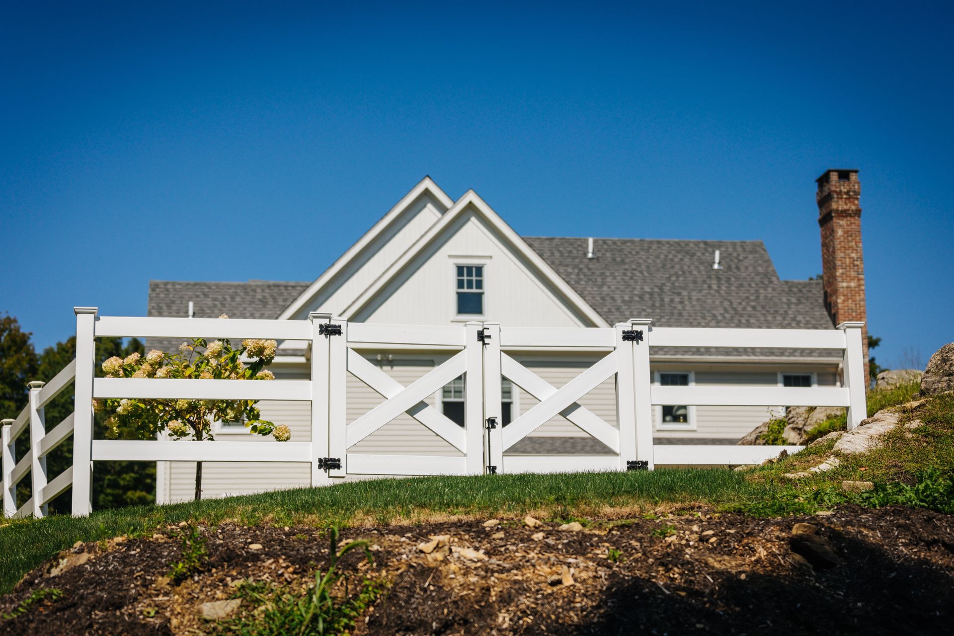 A white house with a white fence in front of it.