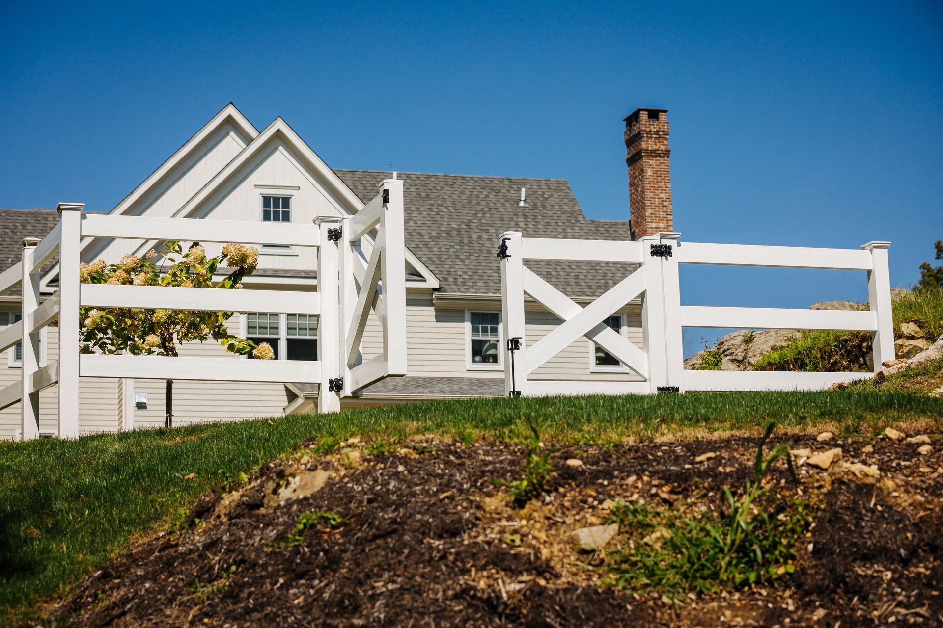 A white house with a white fence in front of it.