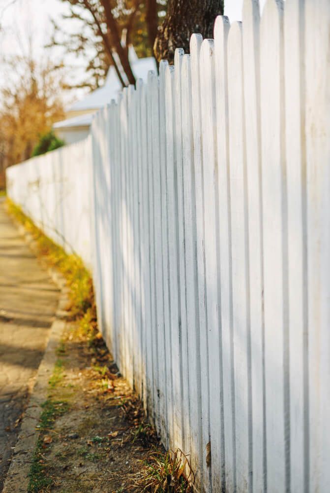 A white picket fence along the side of a road.