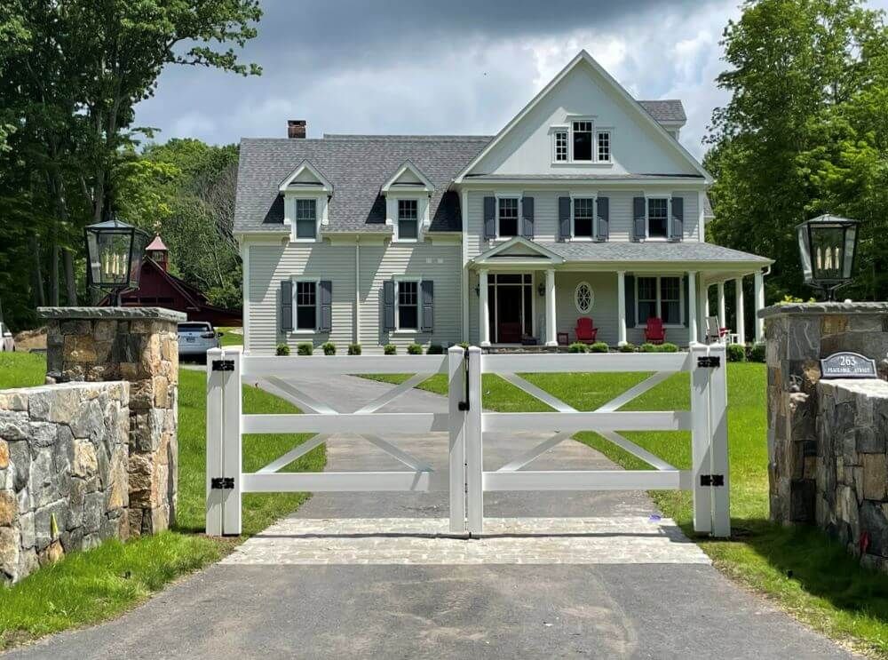 A large white house with a white gate in front of it