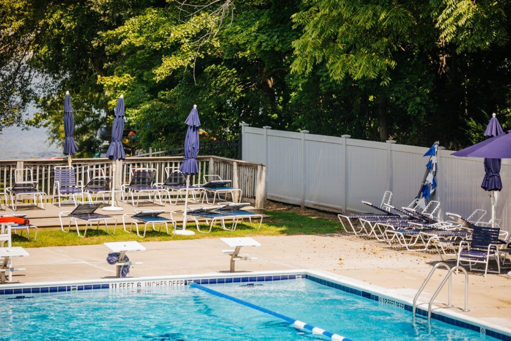 A large swimming pool surrounded by chairs and umbrellas.