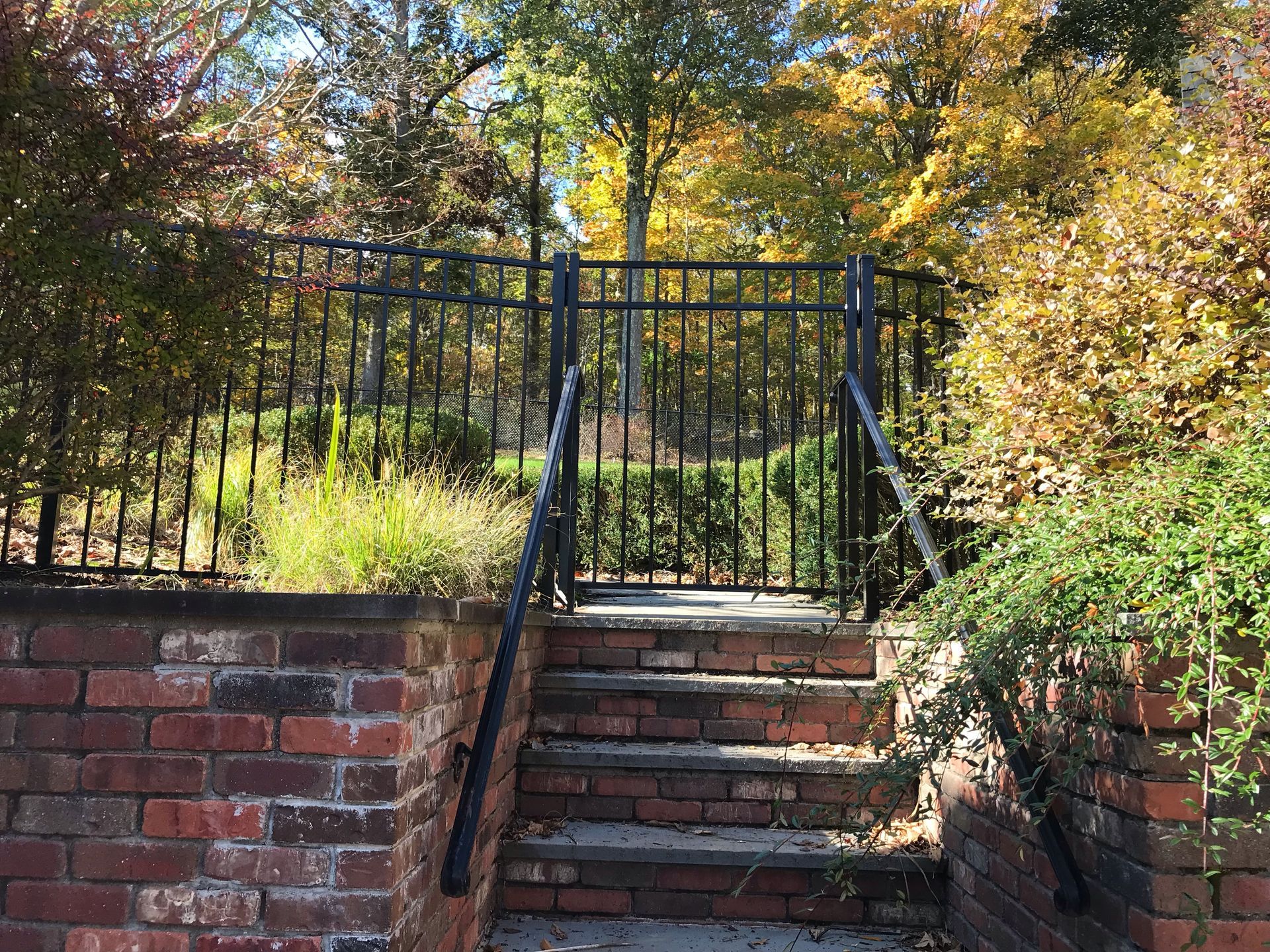 A set of stairs leading up to a fence in a park.