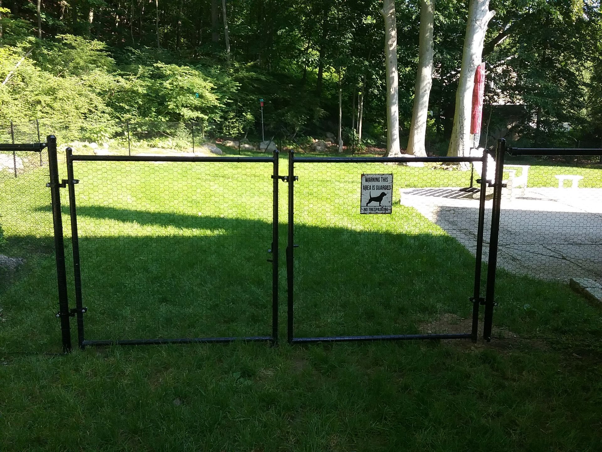 A dog park with a gate and a sign that says no dogs
