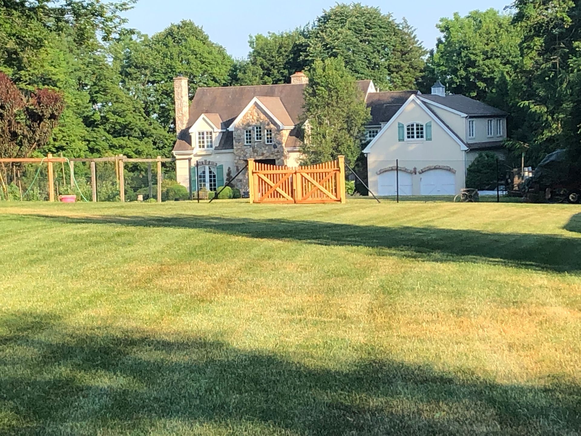 A wooden gate is sitting on the side of a road.