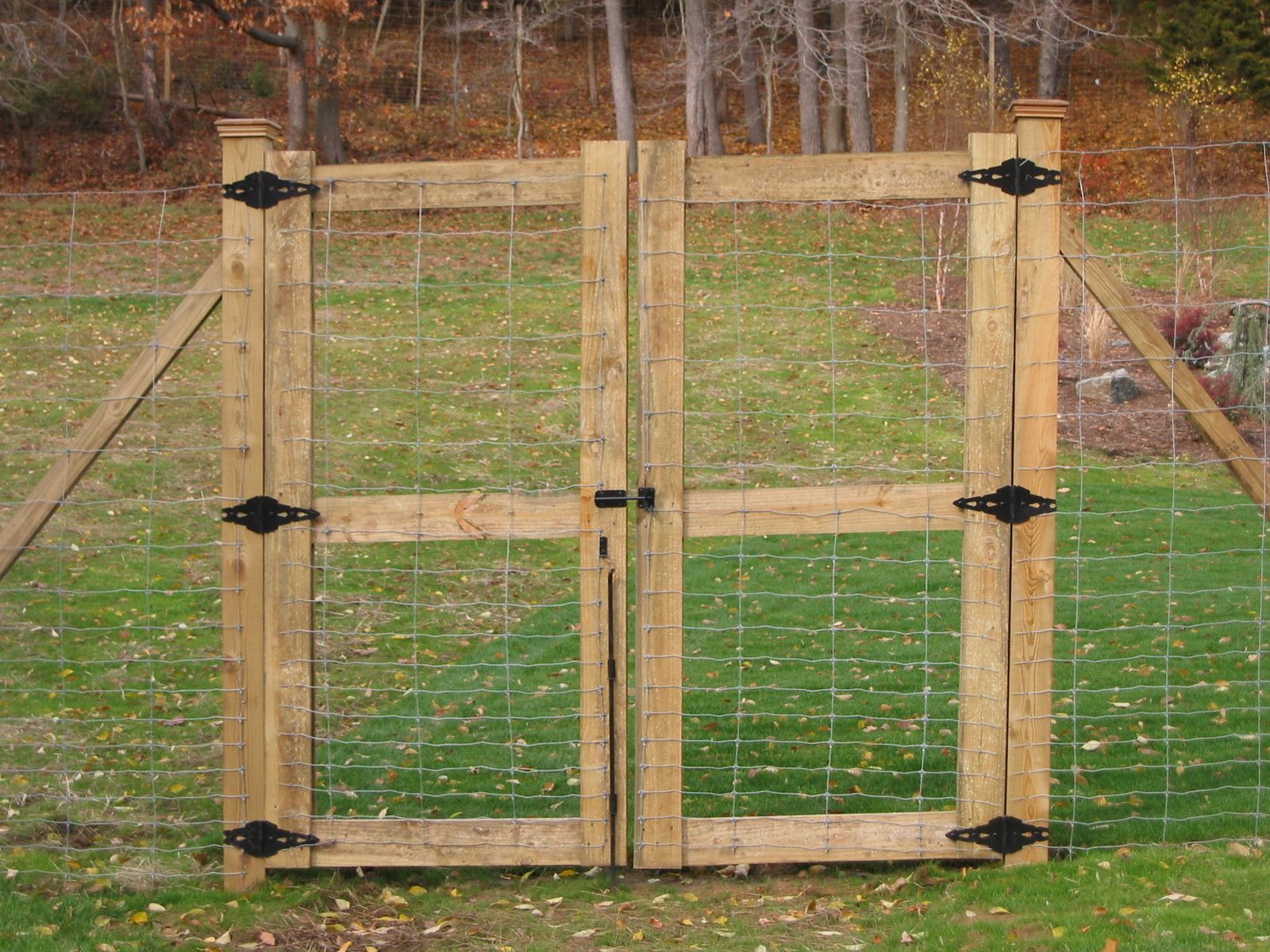 A wooden gate is surrounded by a wire fence
