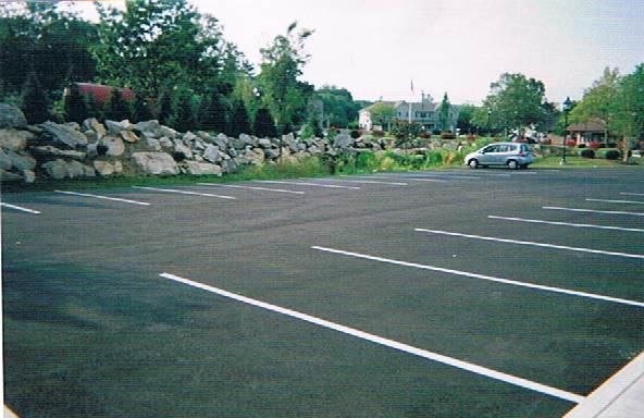 A parking lot with cars parked in it and trees in the background