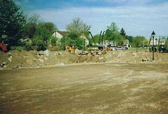 A construction site with a lot of dirt and trees in the background.